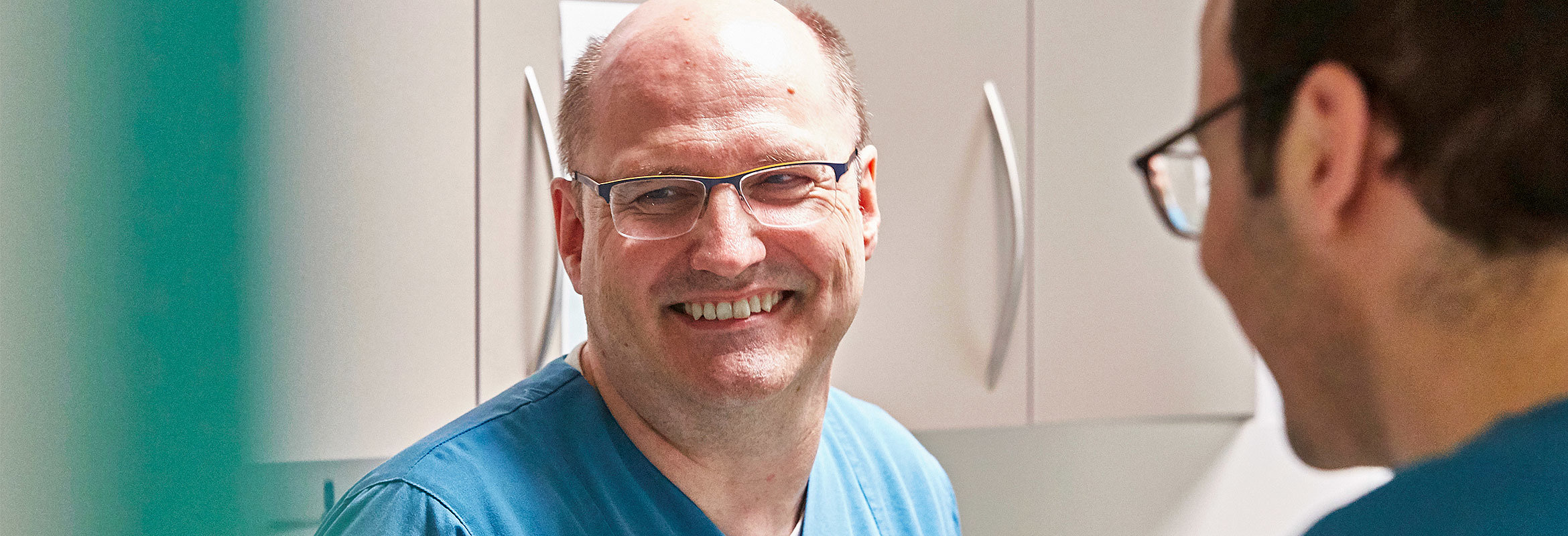 Dr. med. Heiko Bittmann, Chefarzt der Klinik für neurologische und neurochirurgische Frührehabilitation in Kusel, im Gespräch mit einem Mitarbeitenden