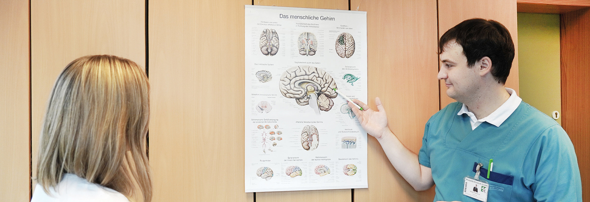 Ein Arzt der Klinik für neurologische und neurochirurgische Frührehabilitation in Kusel erläutert einer Patientin etwas an einem Schaubild