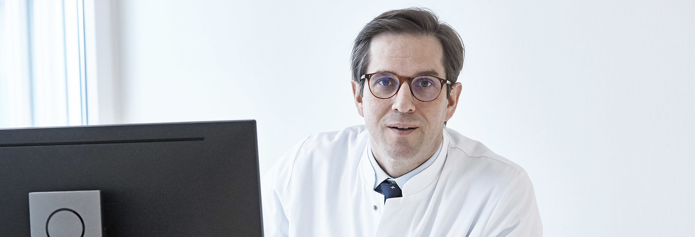 Priv.-Doz. Dr. med. Kajetan von Eckardstein, Chefarzt der Klinik für Neurochirurgie und Wirbelsäulenchirurgie in Kaiserslautern, an seinem Schreibtisch