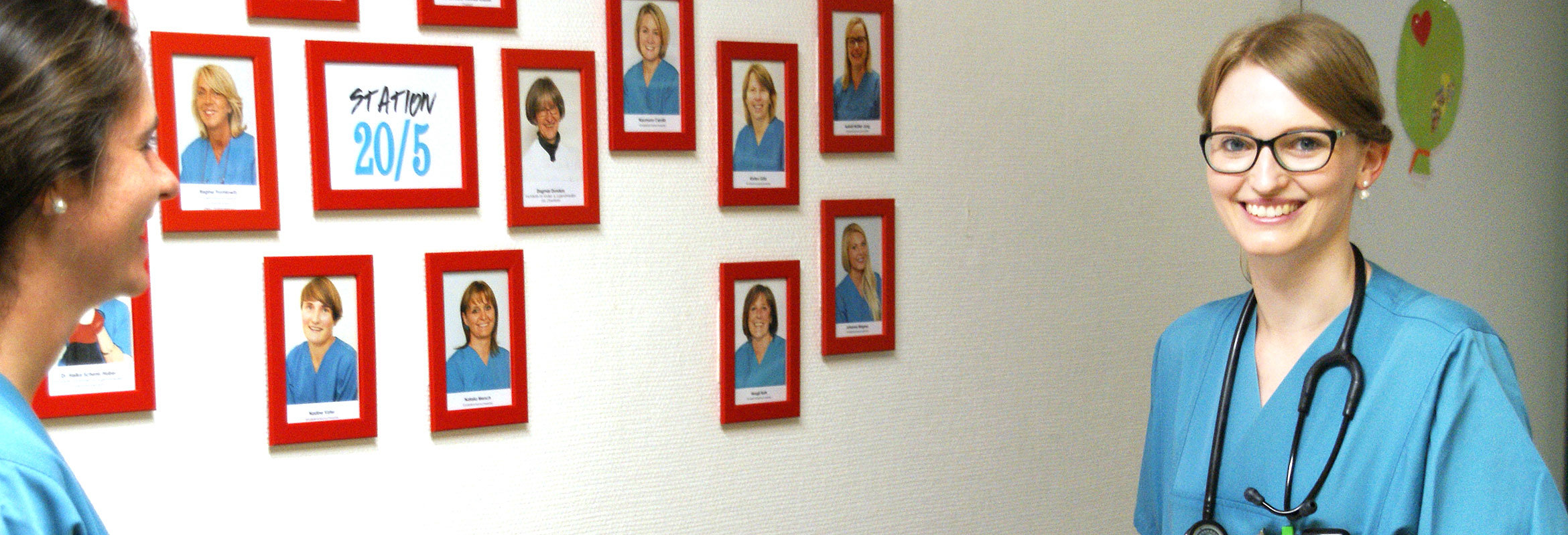 Auf dem Flur der Kinderklinik hängen Bilder von allen Mitarbeiter:innen an der Wand