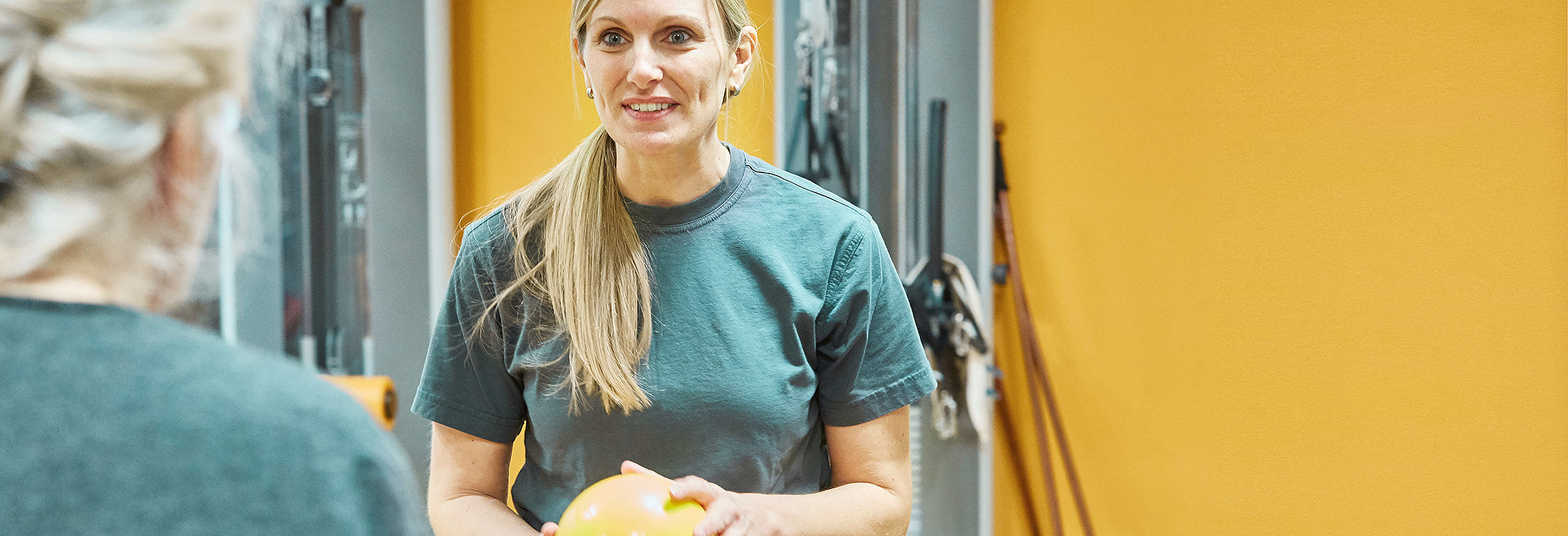 Eine Mitarbeiterin der Abteilung für Physiotherapie in Kusel spielt mit einer Patientin Ball