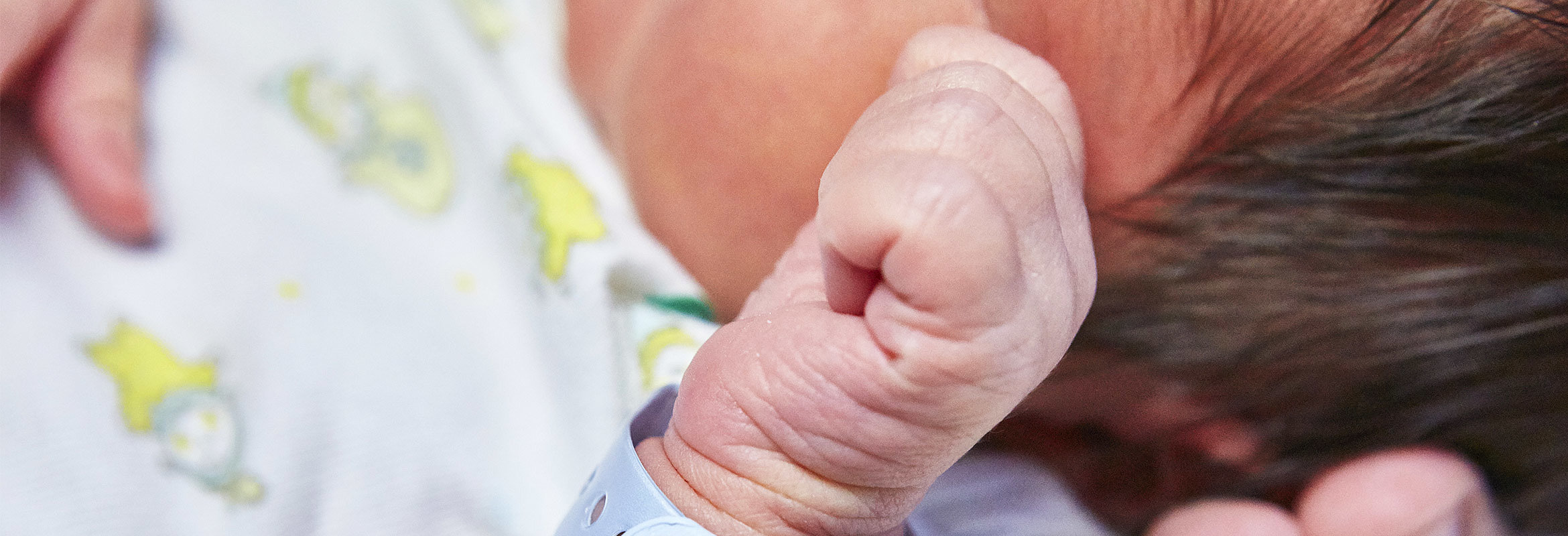 Die Hand eines Babys mit Identifikationsarmband