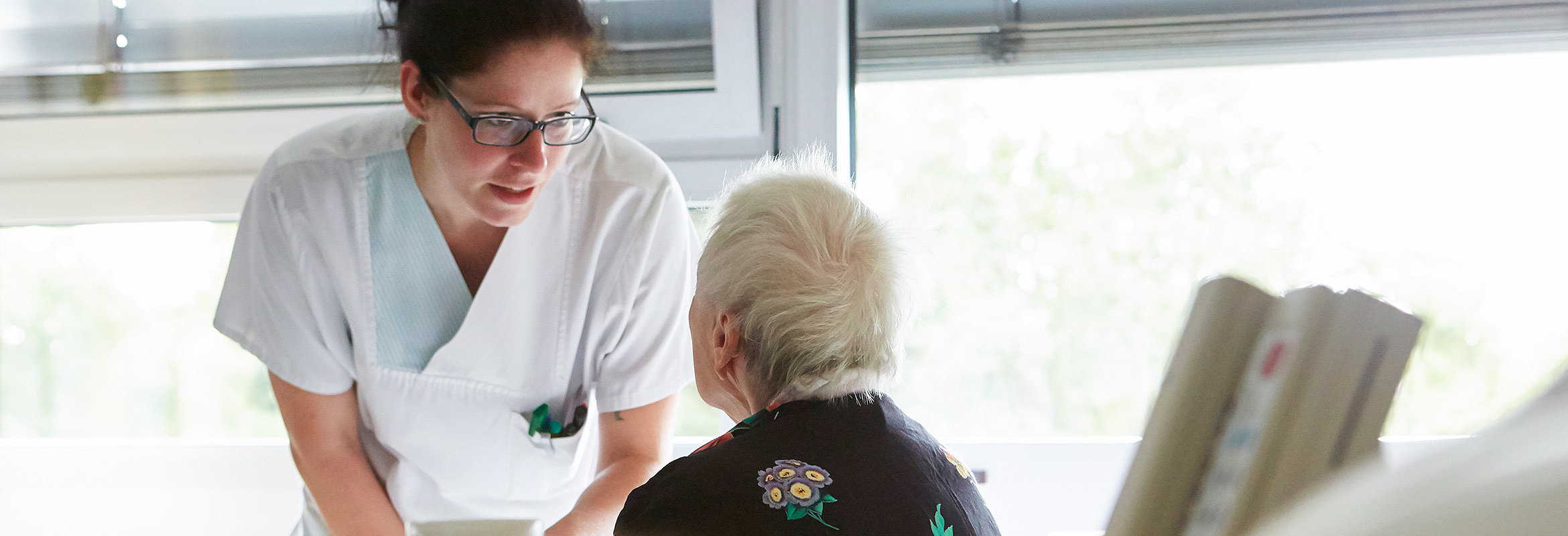 Eine Pflegekraft unterhält sich mit einer Patientin