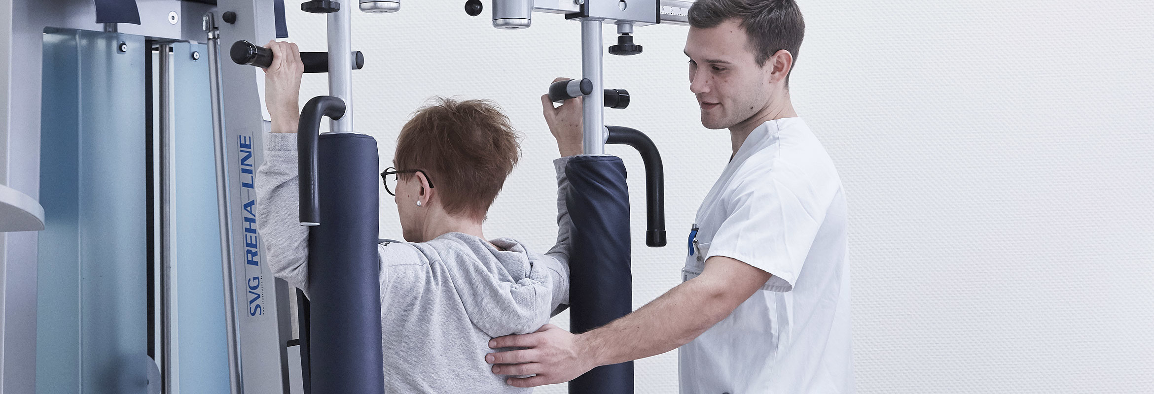 Ein Mitarbeiter der Abteilung für Physiotherapie macht mit einer Patientin Übungen