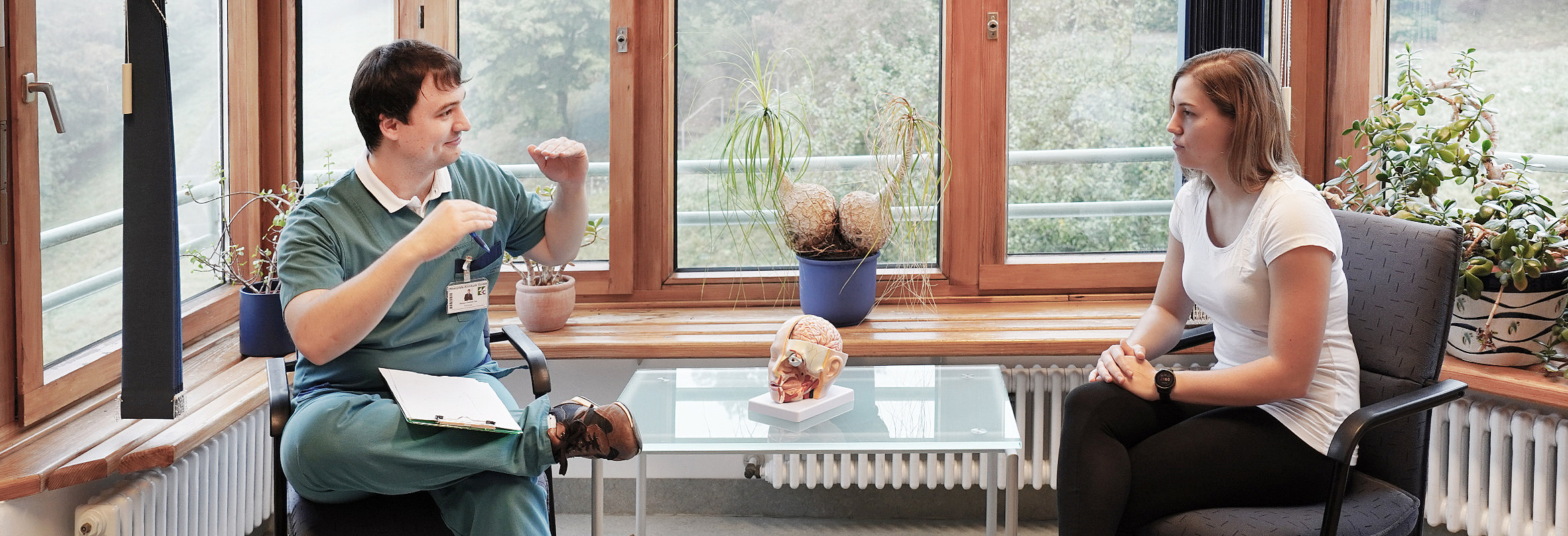 Therapie in der Neuropsychologie: Ein Mitarbeiter der Klinik für neurologische und neurochirurgische Frührehabilitation in Kusel im Gespräch mit einer Patientin